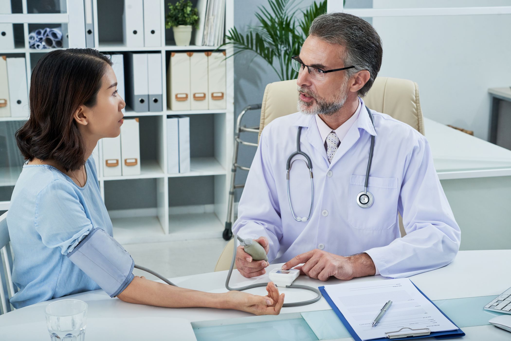 A woman having her blood pressure tested by a doctor
