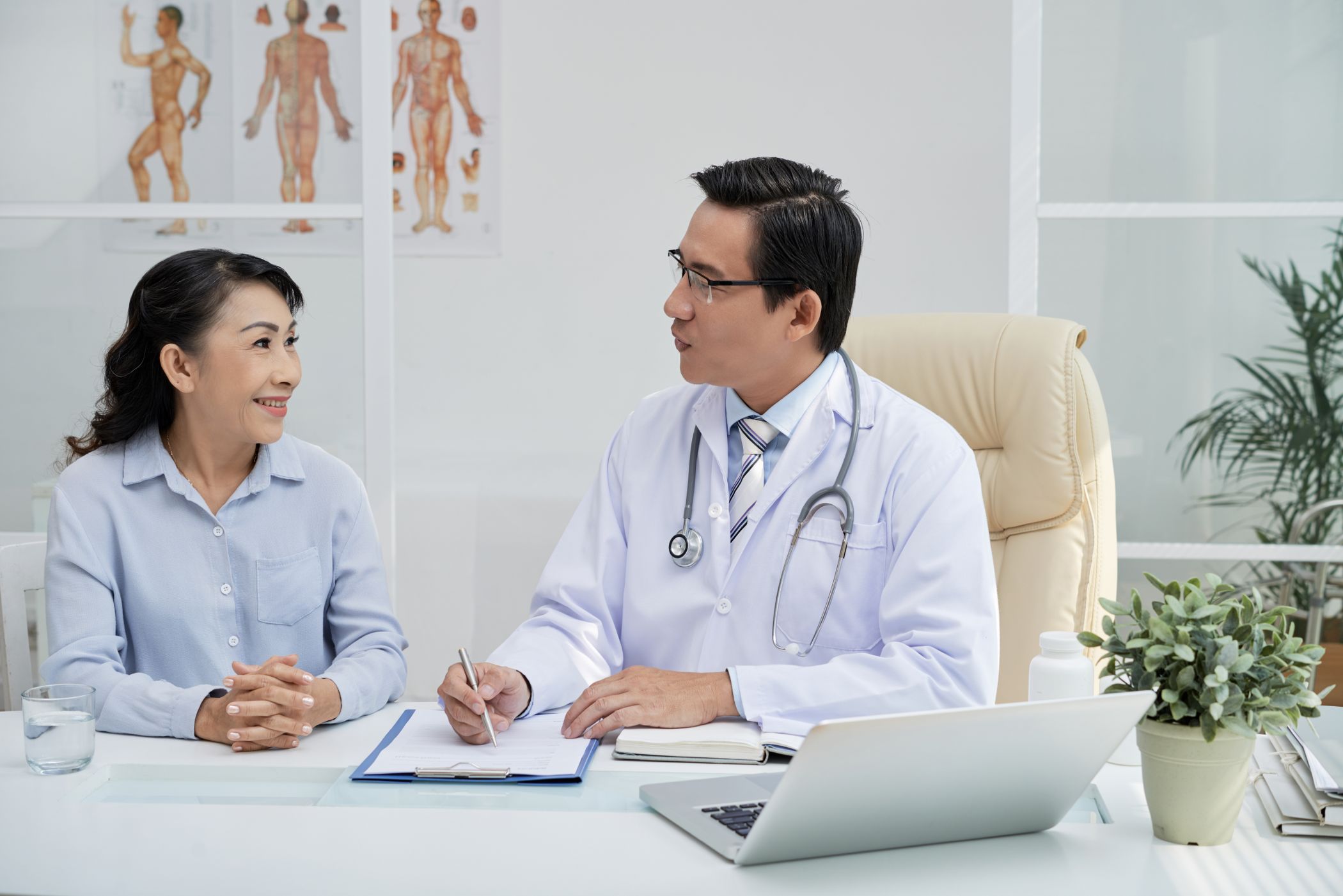 Doctor smiling and explaining paperwork to a patient